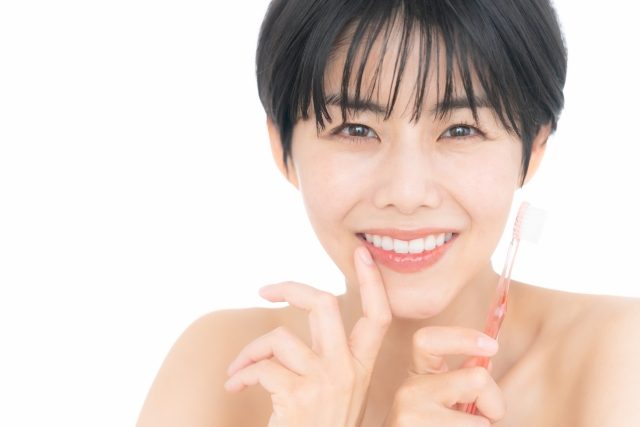 歯ブラシを持つ笑顔の女性 歯ブラシを持つ笑顔の女性